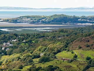 Looking down towards Porthmadog from above Cei Mawr - Palmerston heads a down train towards Penrhyn. In the background, you can see the Cob and out to the Llyn Peninsula